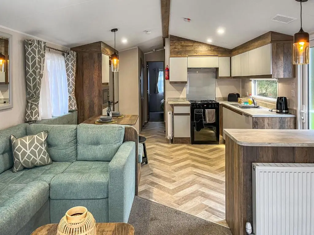 a living room with a couch and a kitchen at The Kestrel - Ukc6920 in Forres