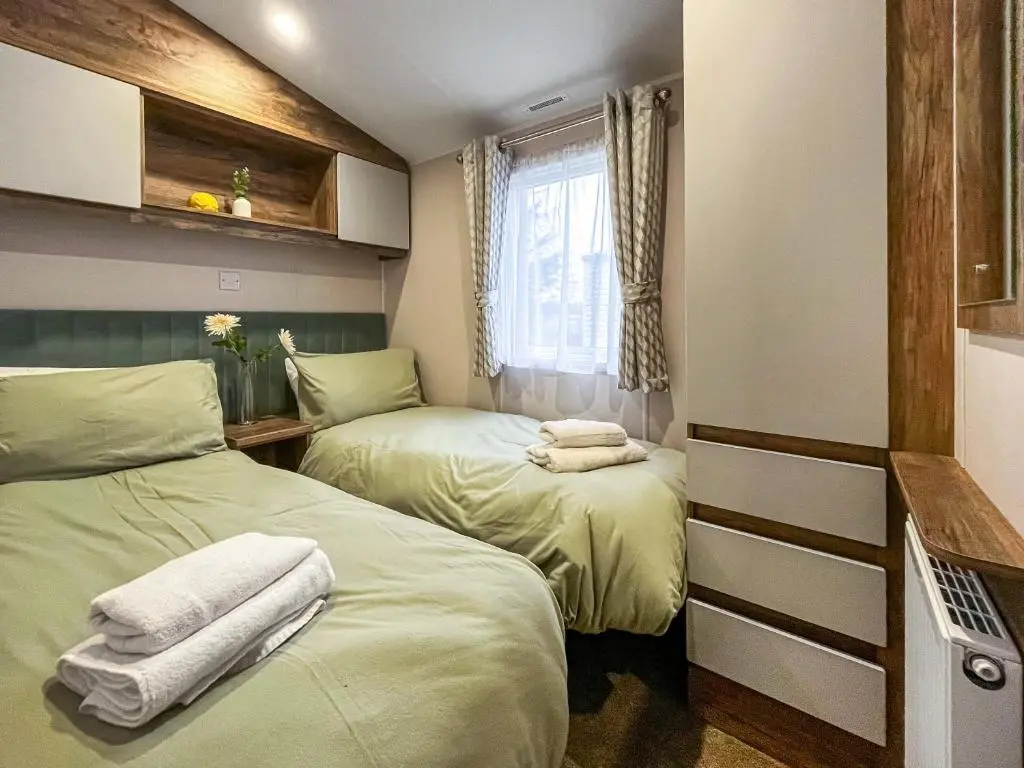 two beds in a small room with a window at The Kestrel - Ukc6920 in Forres