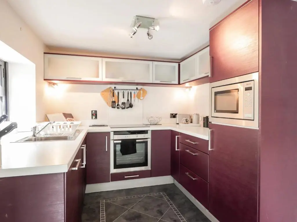 a kitchen with purple cabinets and a sink at Mary Ann Apartment in Inverness