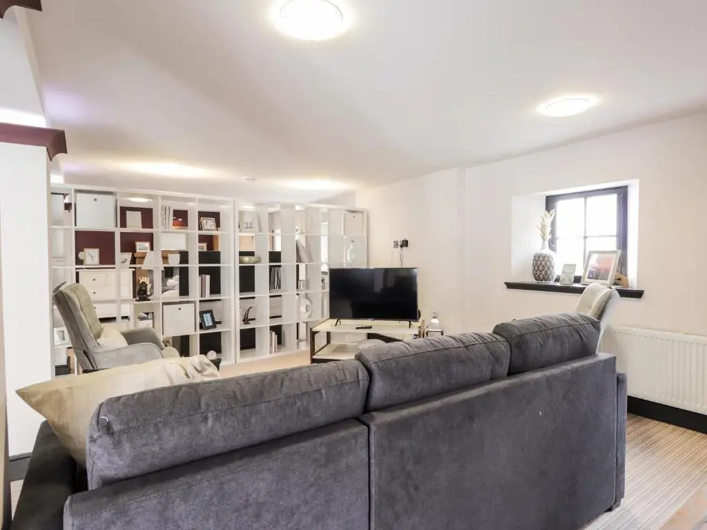 a living room with a couch and a television at Mary Ann Apartment in Inverness
