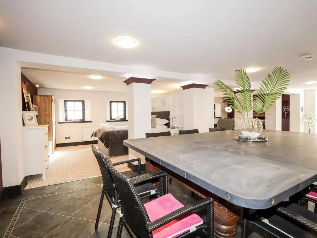 a dining room and living room with a table and chairs at Mary Ann Apartment in Inverness