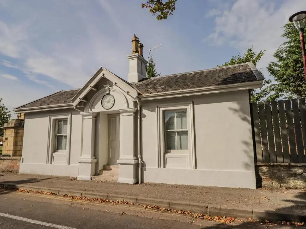 a small white building with a clock on it at Porter's Lodge in Inverness
