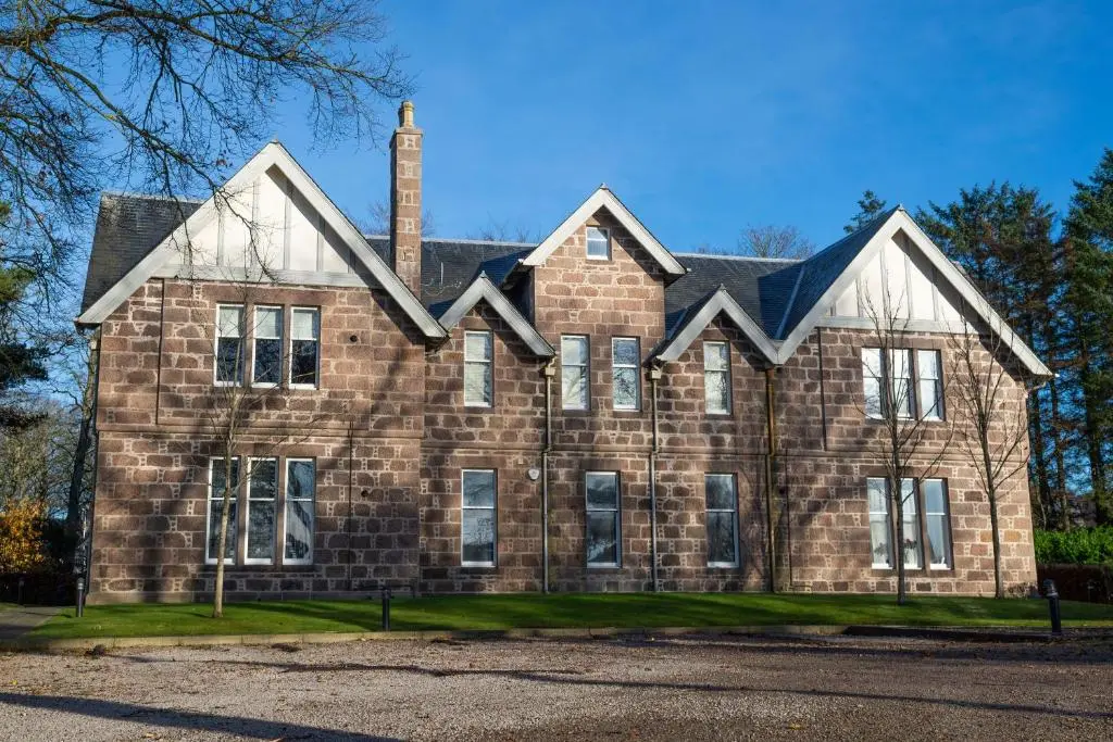 a large brick building with a chimney on top at Junique Modern Ground Floor Apartment - 2 bedrooms in Aberdeen