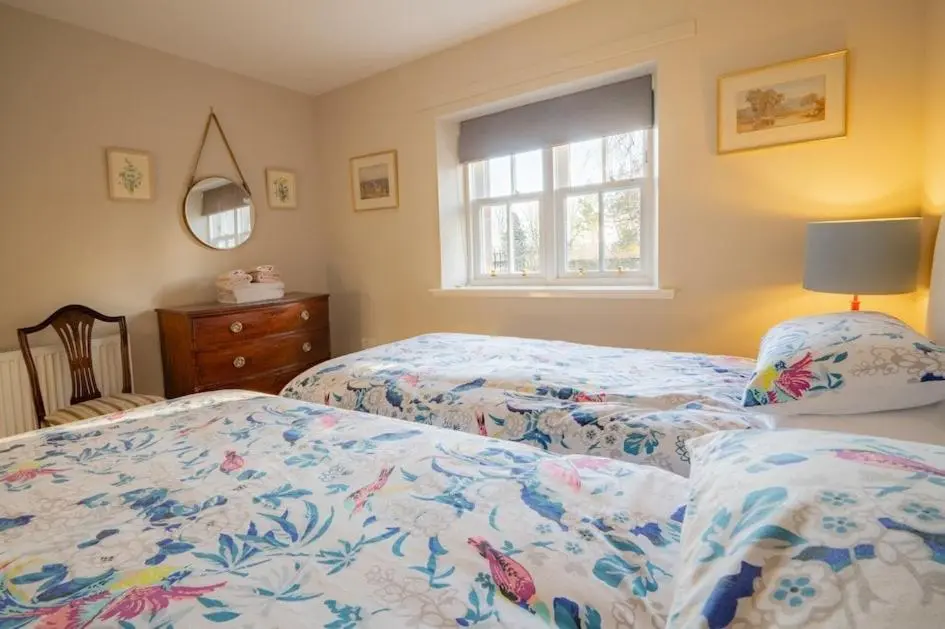 a bedroom with two beds and a window at Foulis Castle Gate Lodge in Evanton