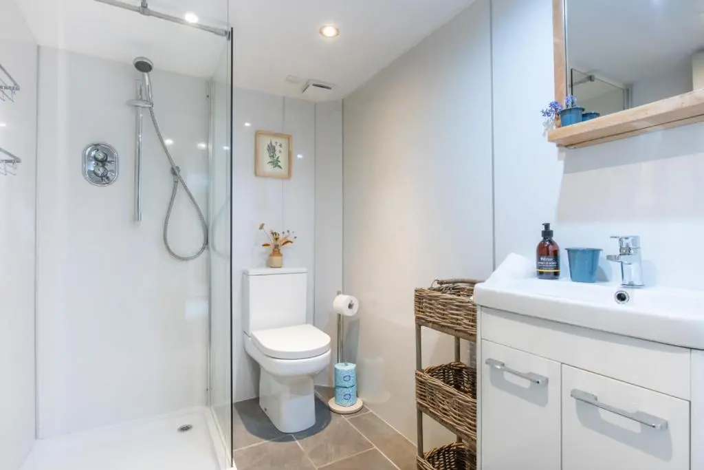 a bathroom with a shower and a toilet and a sink at Weavers Cottage in Inverness
