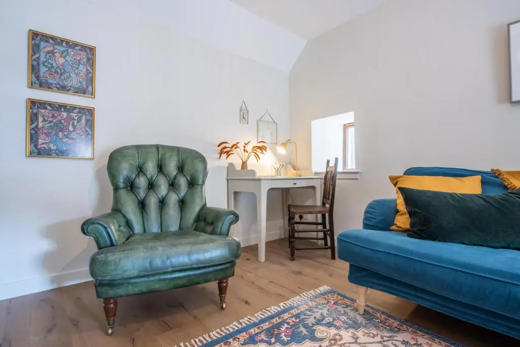 a living room with a couch and a chair at Weavers Cottage in Inverness