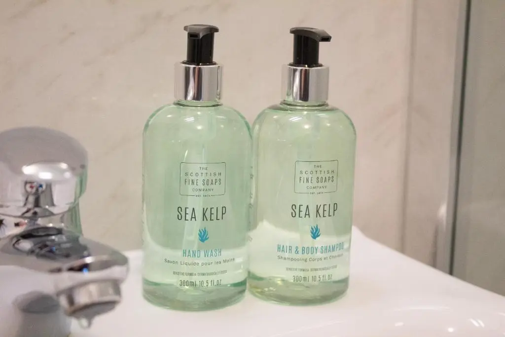 two bottles of soap sitting on a bathroom sink at Telford Cottage in Kincraig