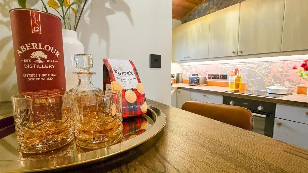 two glasses of whiskey on a table in a kitchen at Telford Cottage in Kincraig