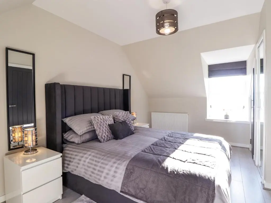 a bedroom with a large bed and a window at 3 The Granary in Banff
