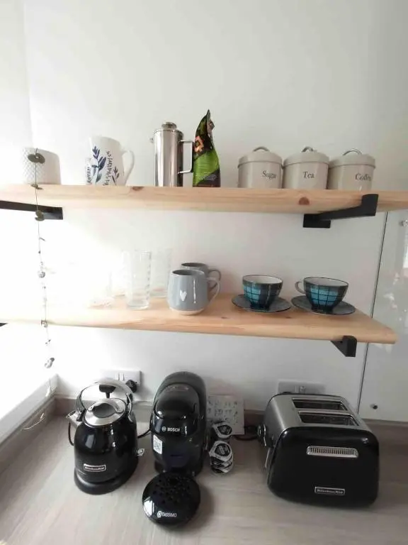 a kitchen with a toaster and appliances on a shelf at River Retreat - Riverside Apartment in Inverness City Centre in Inverness