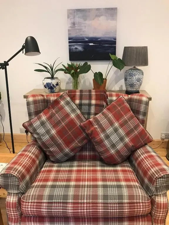 a couch with pillows on it in a living room at River Retreat - Riverside Apartment in Inverness City Centre in Inverness