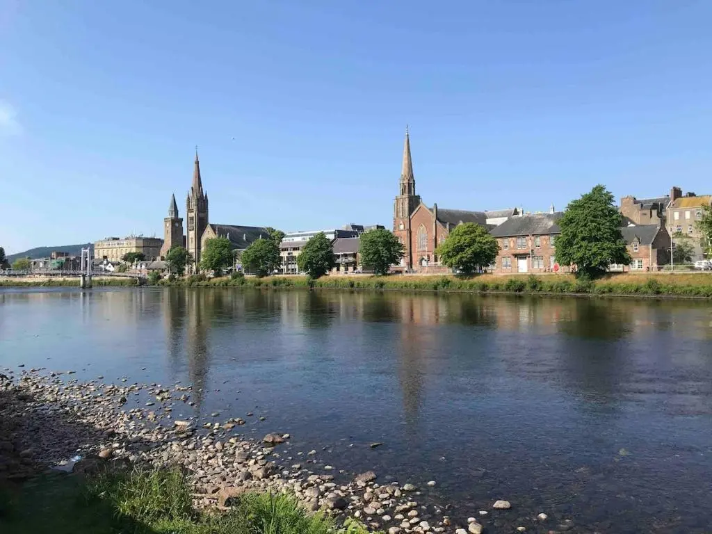 a view of a river with a city in the background at River Retreat - Riverside Apartment in Inverness City Centre in Inverness