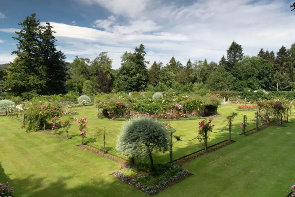 a garden with flowers and plants in a field at Swiss Cottage in Ballindalloch