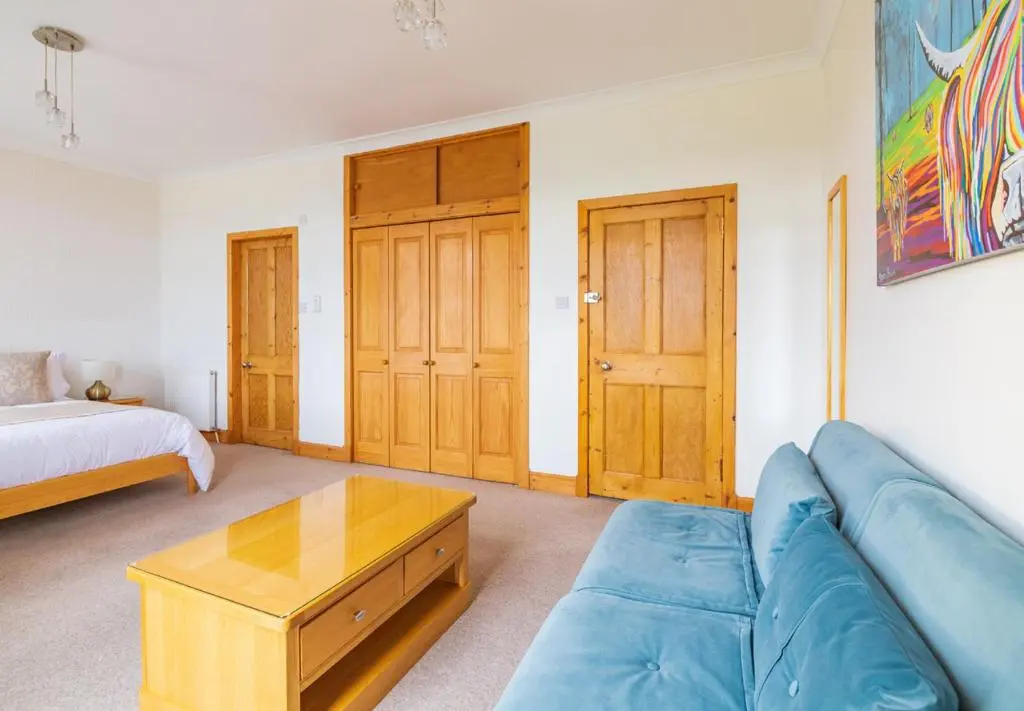a living room with a blue couch and a coffee table at Strathview Lodge B&B in Dornoch