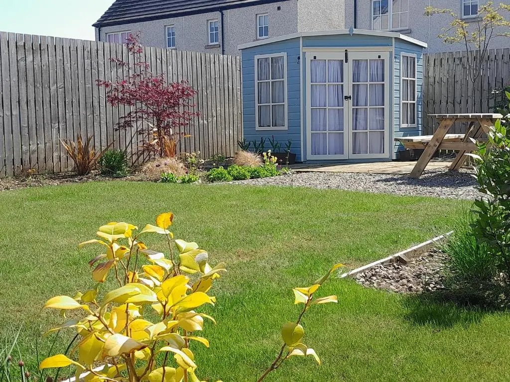 a yard with a fence and a house with a yard at No1Dornoch in Dornoch