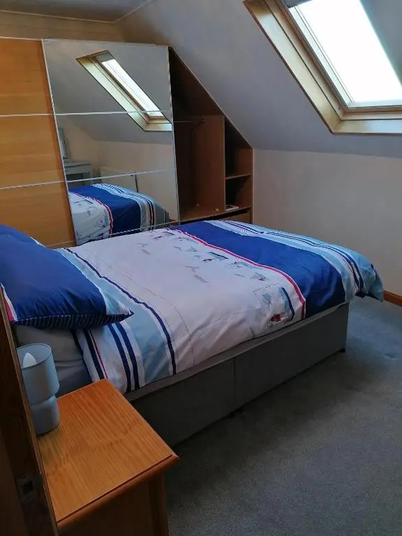 two beds in a bedroom with two windows at Hytheview Cottage Whitehills in Whitehills