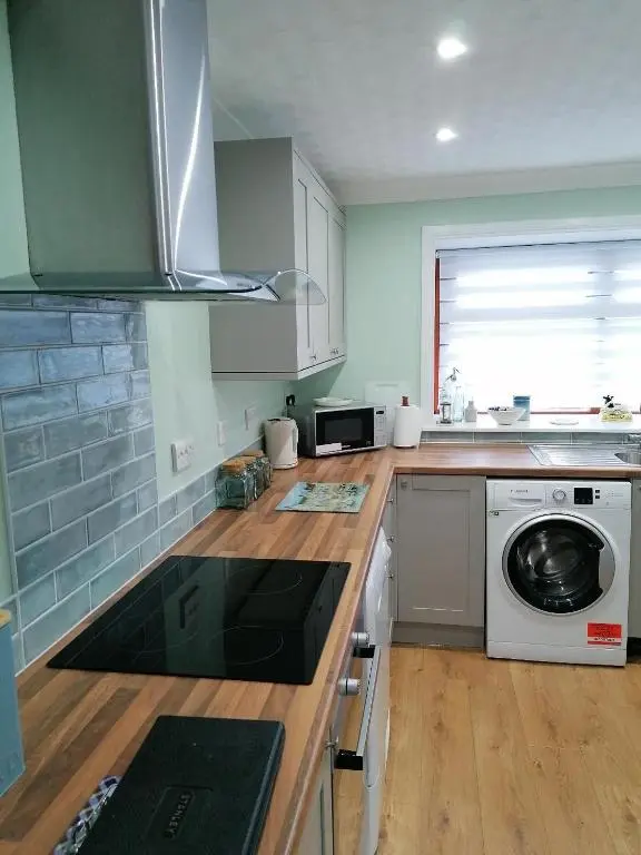 a kitchen with a washer and dryer on a counter at Hytheview Cottage Whitehills in Whitehills