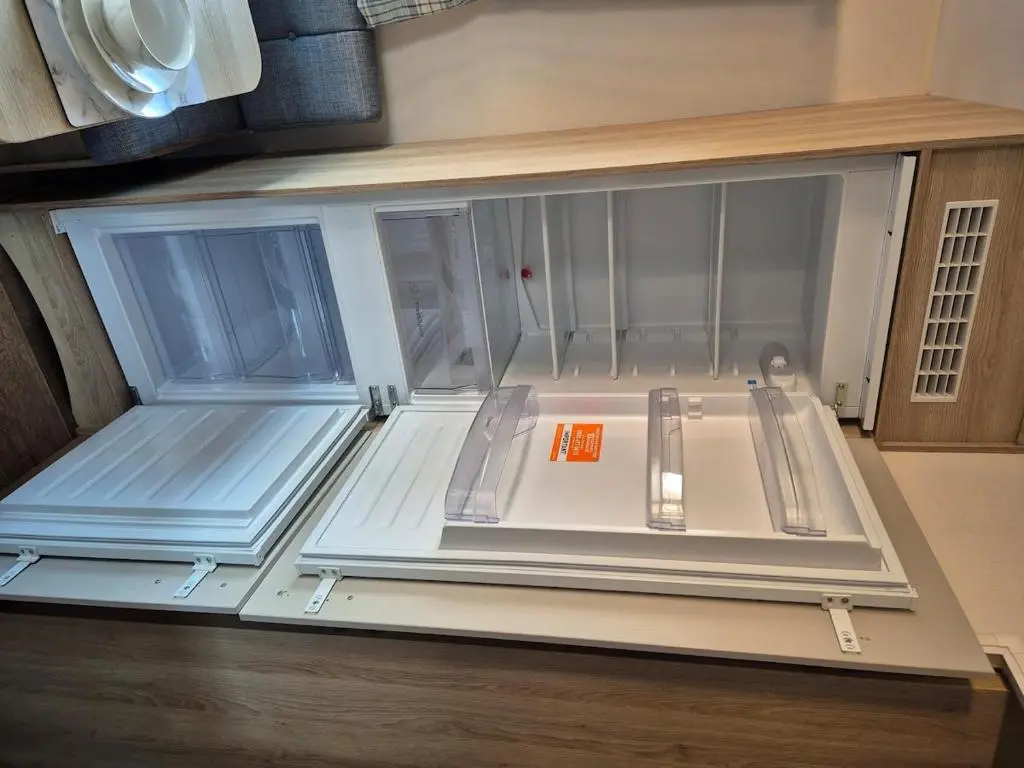 an empty refrigerator with its door open in a kitchen at Badgers Den Silversands in Lossiemouth