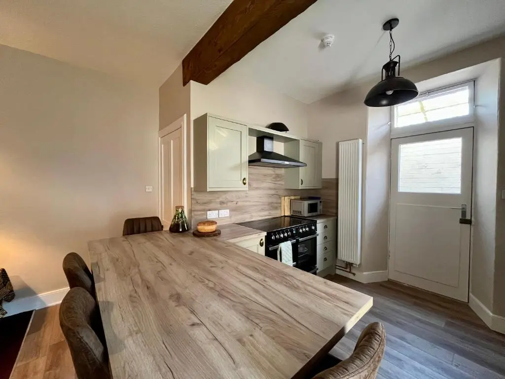 a kitchen with a large wooden table in a room at The Farmhouse Snug in Spean Bridge