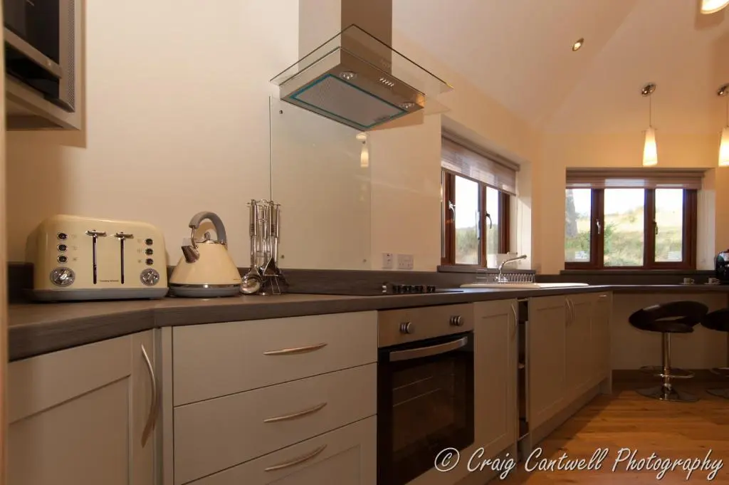 a kitchen with white cabinets and a counter top at Dalnoid Cottages & Treehouses Nr Glenshee in Glenshee