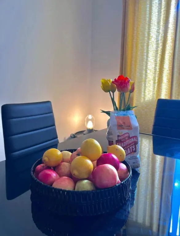 a basket of fruit on a table with a vase of flowers at Charming City Centre Flat in Inverness