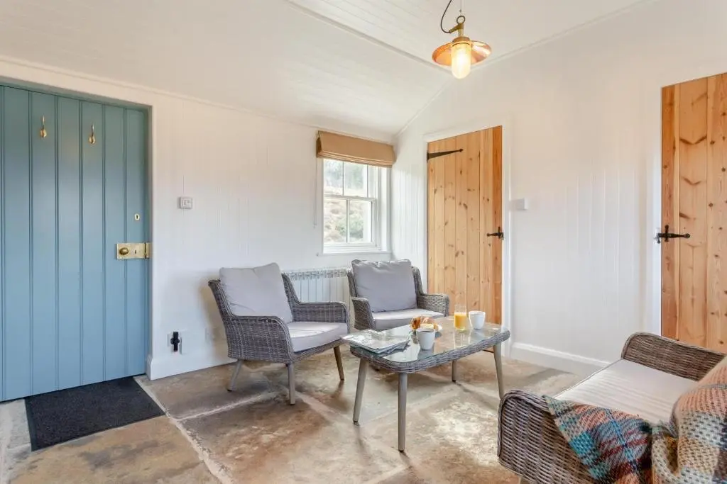 a living room with two chairs and a table at 2 Bed in Ardgay oc-w30780 in Achnahanat
