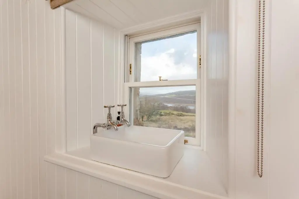 a white sink in a bathroom with a window at 2 Bed in Ardgay oc-w30780 in Achnahanat