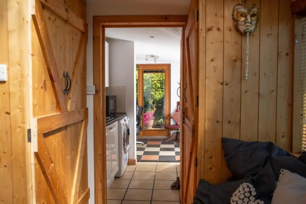 a hallway leading to a kitchen with wooden walls at Den of Allachlade in Aboyne