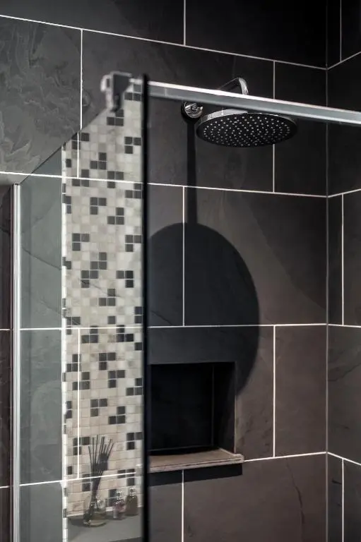 a shower with a glass door in a bathroom at Holly Tree Cottage in Dornoch