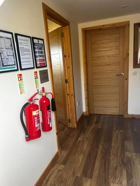 a room with two red fire extinguishers on the wall at Druid Apartment in Inverness