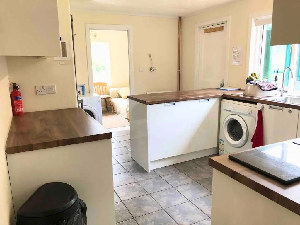 a kitchen with a washer and a washing machine at Canal Side Cottage,on the banks of the Caledonian Canal in Inverness