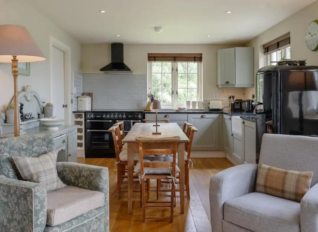 a kitchen with a table and chairs in a kitchen at Brachkashie Cottage, Loch Knockie in Whitebridge