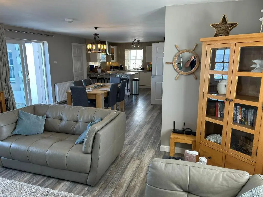 a living room with a couch and a kitchen at Findochty Beach house - Private Garden-BeachFront in Buckie