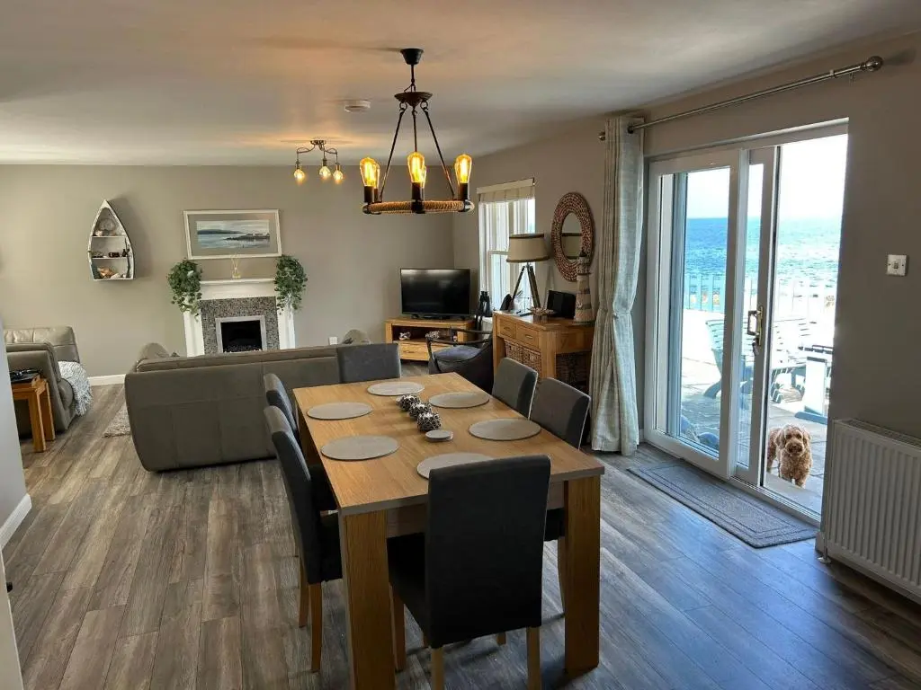 a dining room and living room with a table and a couch at Findochty Beach house - Private Garden-BeachFront in Buckie