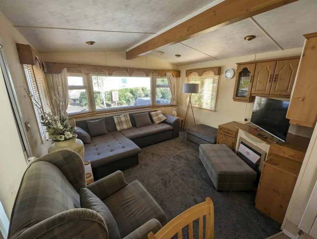 a living room with a couch and a tv at Highland getaway in kingussie golf club in Kingussie