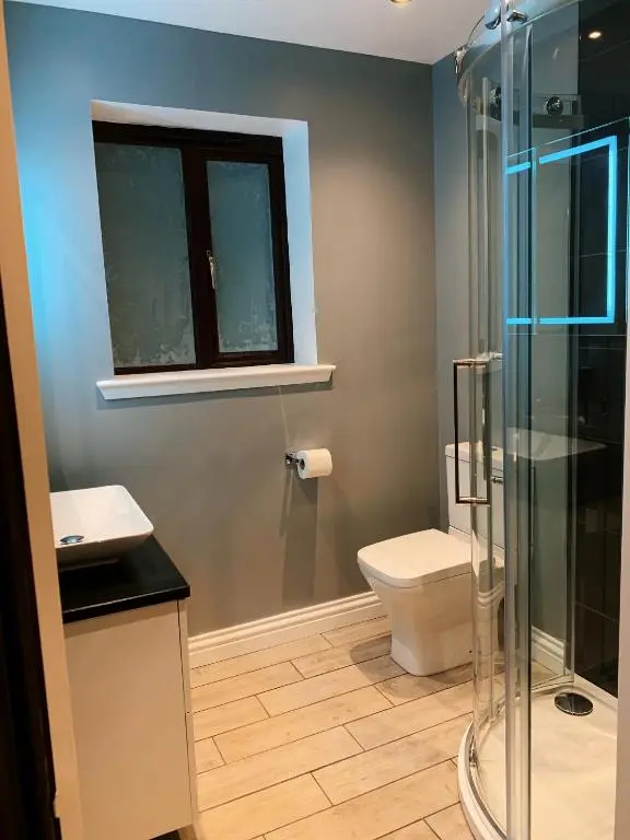 a bathroom with a toilet and a glass shower at Appin House B&B in Fort Augustus