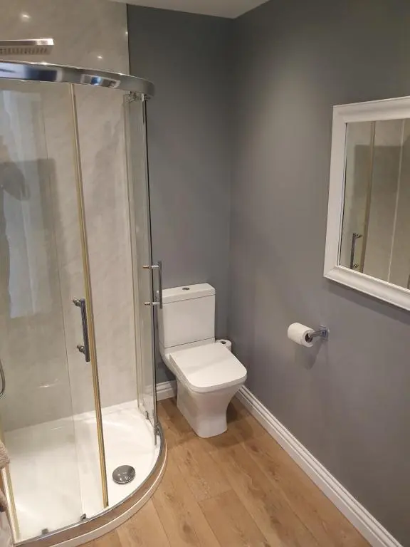 a bathroom with a toilet and a glass shower at Appin House B&B in Fort Augustus