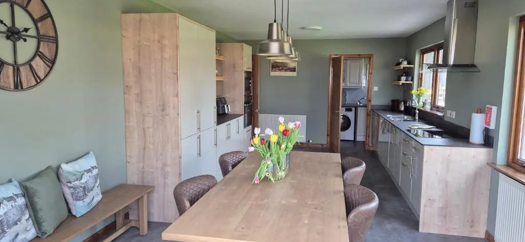 a kitchen with a table with a vase of flowers on it at Dail Daraich in Munlochy