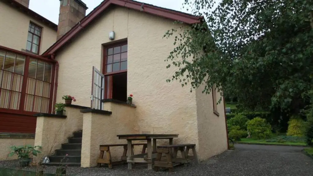 a picnic table in front of a house at Strathpeffer Holiday Cottages in Strathpeffer