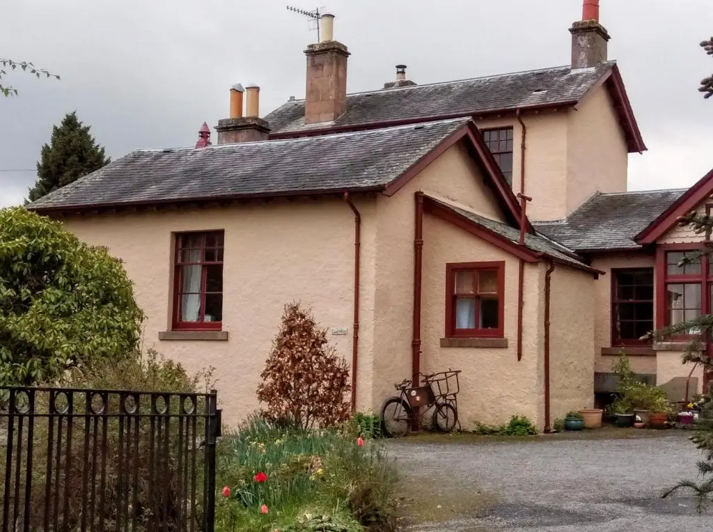 a house with a bicycle parked in front of it at Strathpeffer Holiday Cottages in Strathpeffer