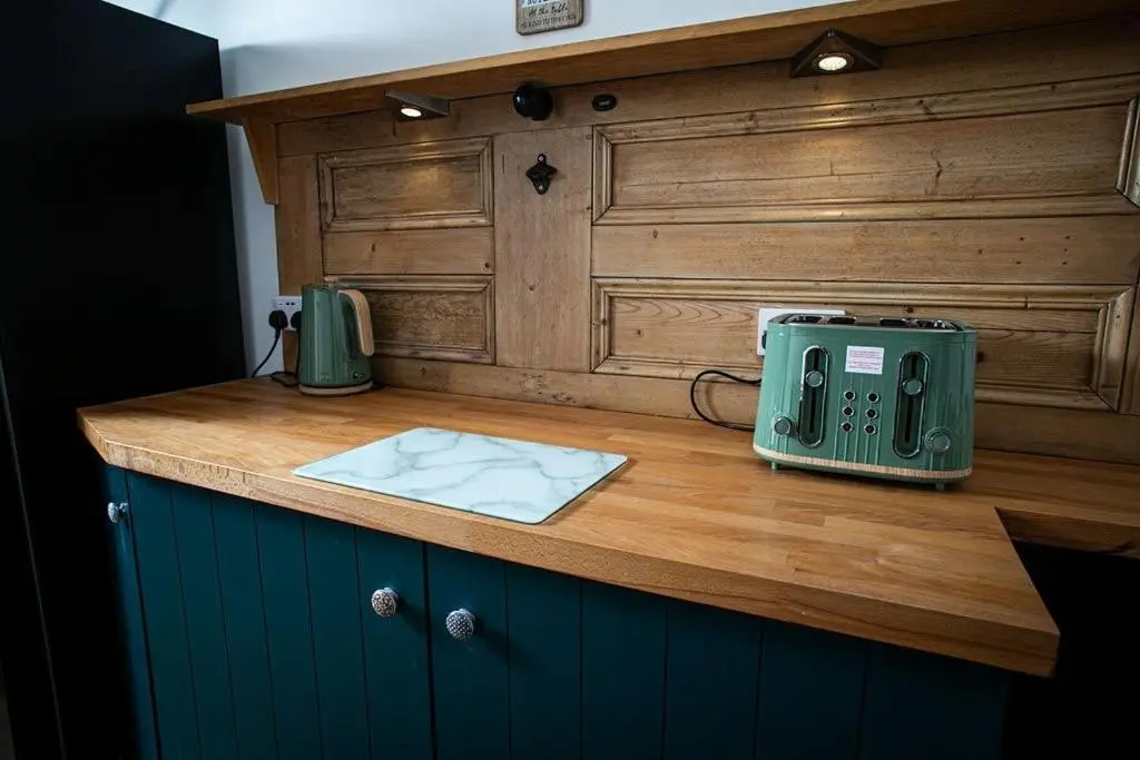 a kitchen counter with a green appliance on a wooden counter top at Castle Grant - 4 Bed Cottage in Gardenstown in Gardenstown