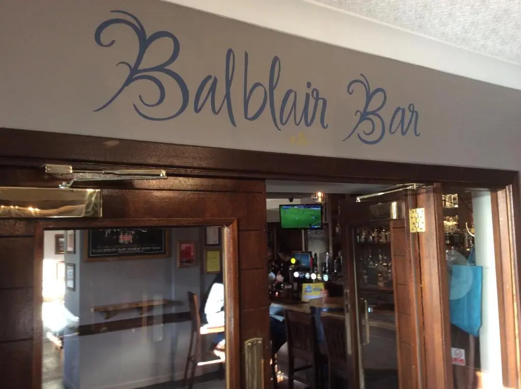 a restaurant with a bar sign over the door at Eagle Hotel in Dornoch