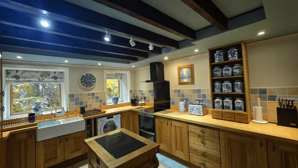 a large kitchen with a sink and a dishwasher at The Old Stables in Fort Augustus