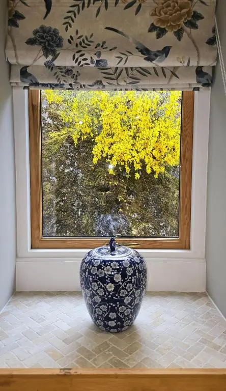 a blue and white vase sitting in front of a window at The Old Stables in Fort Augustus