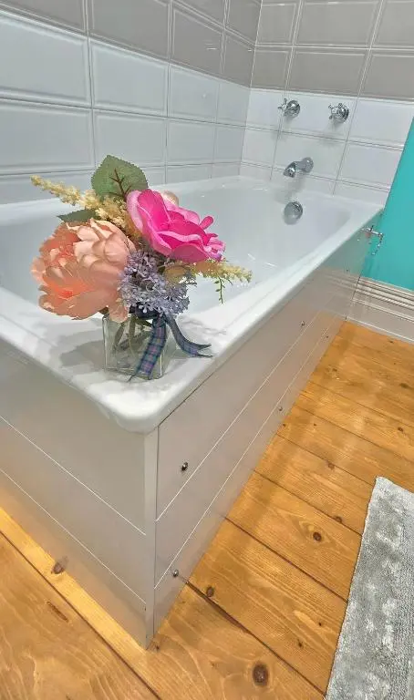 a vase of flowers sitting on top of a bath tub at The Old Stables in Fort Augustus