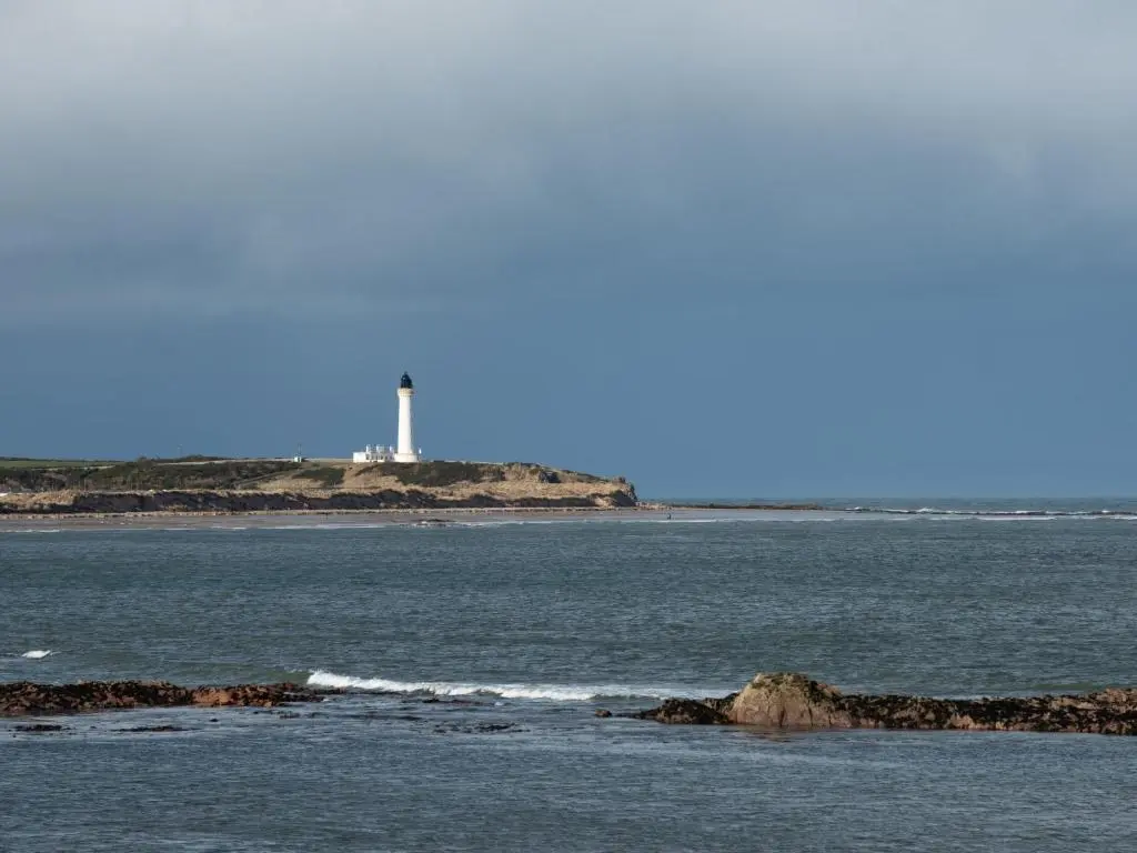 a body of water with a lighthouse in the distance at Apartment Harbour Nights Deluxe 7F by Interhome in Lossiemouth