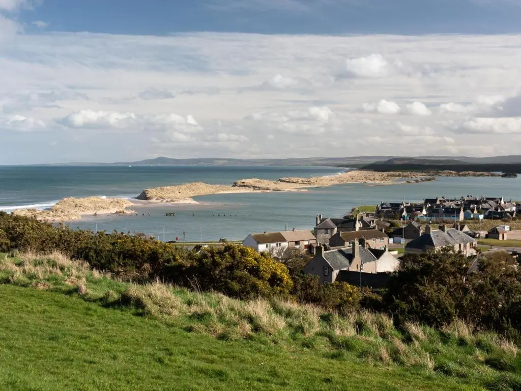 a group of houses on a hill next to the ocean at Apartment Harbour Nights Deluxe 7F by Interhome in Lossiemouth