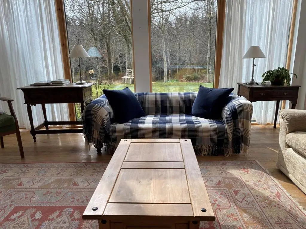 a living room with a couch and a coffee table at Spacious, cosy 6 bedroom house which sleeps 11 in Banchory