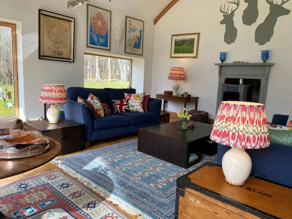 a living room with a blue couch and a fireplace at Spacious, cosy 6 bedroom house which sleeps 11 in Banchory