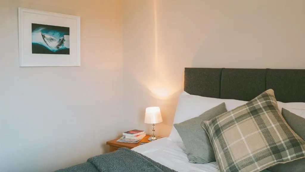 a bedroom with a bed and a picture on the wall at Cairn Eilrig - Seasgair Lodges in Loch Morlich